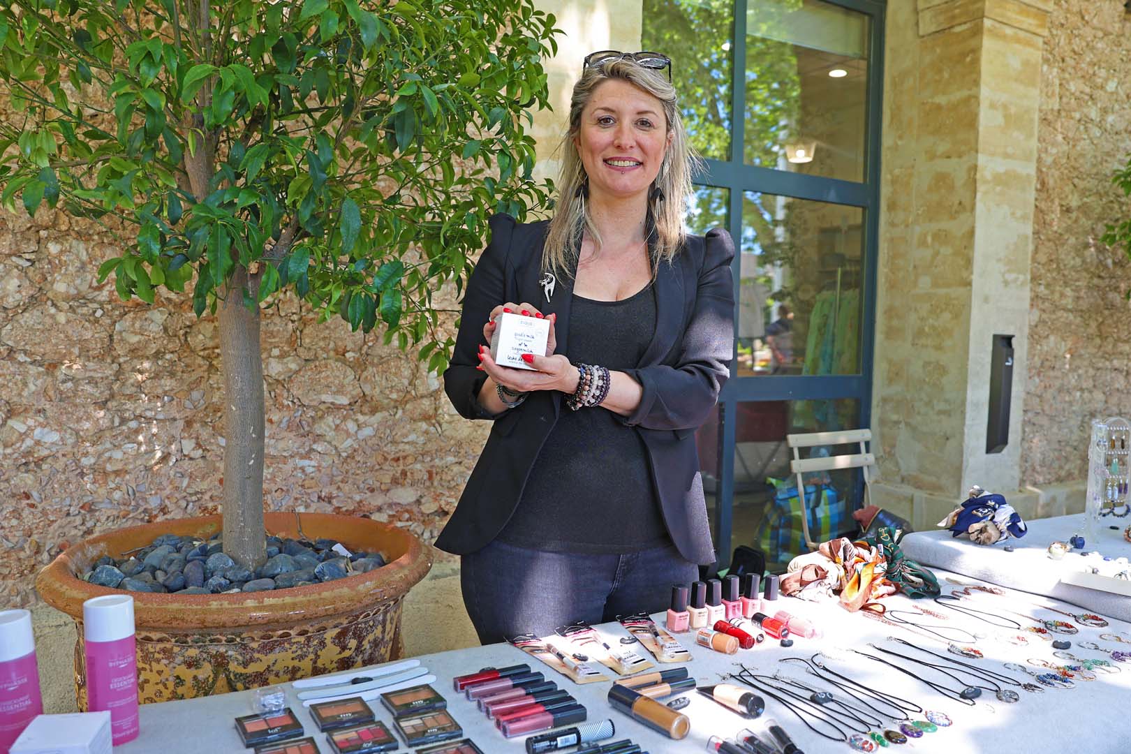 Jenny tient le stand de la boutique Mademois « Elles » qui propose des crèmes, huiles, lotions, maquillage et pierres naturelles, disponibles sous formes de bijoux fantaisie